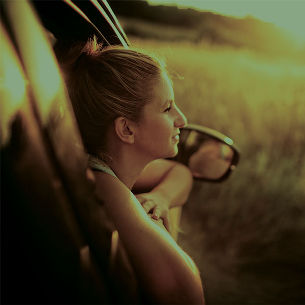 Woman looking out window of car door